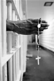 An inmate with a jail issued cross inside the segregation unit at Pitchess Honor Rancho, one of the ten different units that comprise the sprawling Los Angeles County Jail system which houses 21,000 inmates, the world's largest jail population.