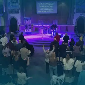 Image of worship in church with purple lighting - Events page