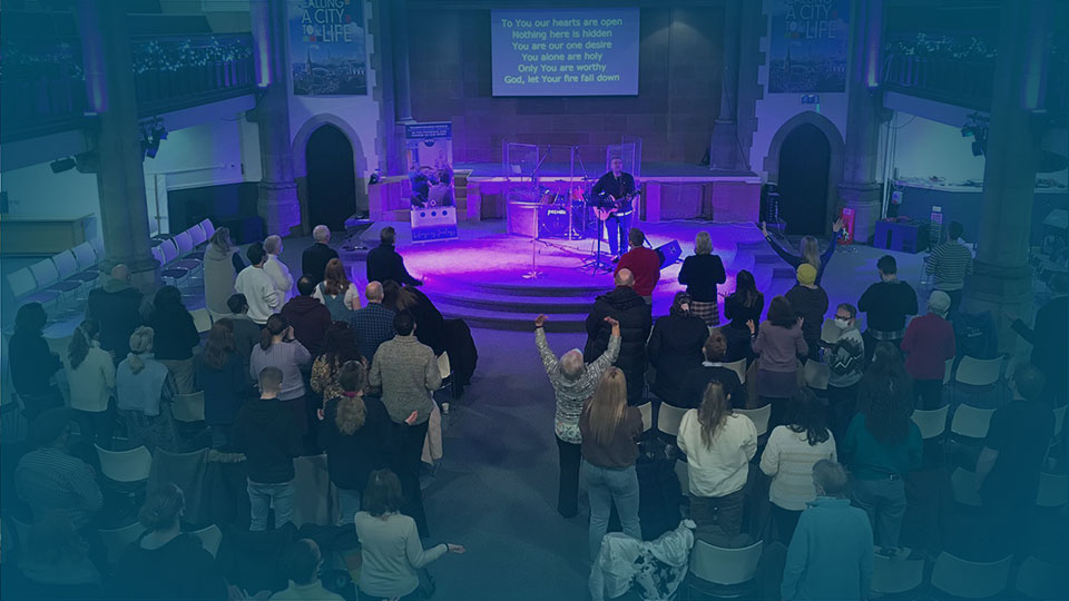 Image of worship in church with purple lighting - Events page