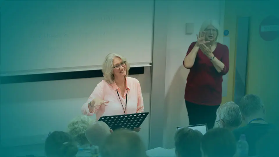 Image of Lucy Peppiatt teaching with sign language interpreter next to her - Programmes page