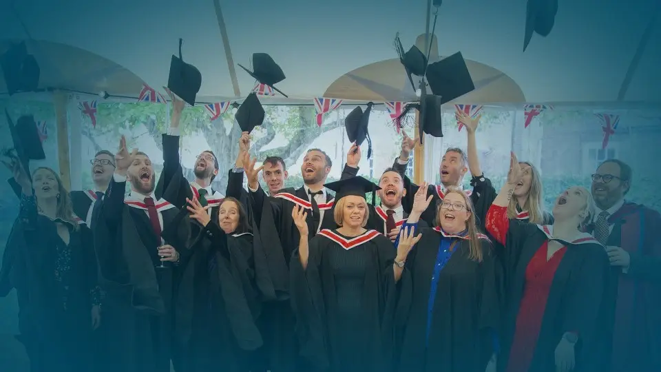 WTC Alumni image throwing flatcaps in the air